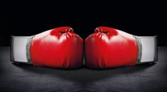 Zwei rote Boxhandschuhe auf schwarzem Hintergrund.