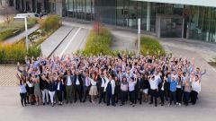 This image shows CODICO employees waving in front of the office building.