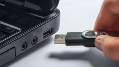 Ein USB-Stick wird an einen Laptop angeschlossen.